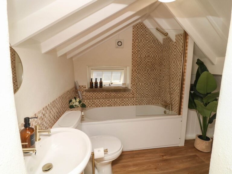 The bathroom with bath and shower over