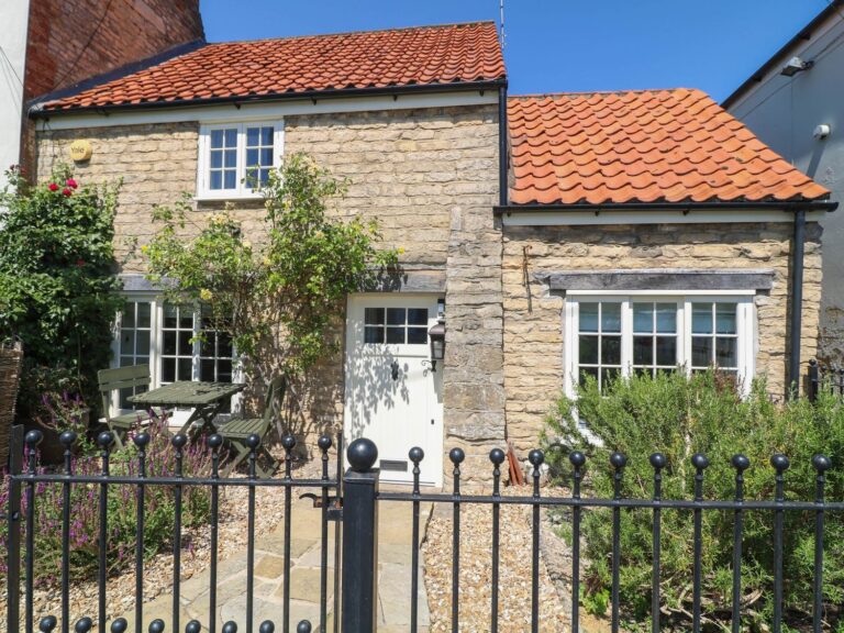 The front of Freya's Cottage behind its iron gate