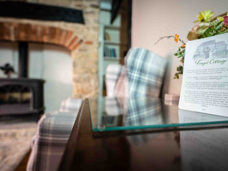 The Freya's Cottage welcome card beside the fireplace